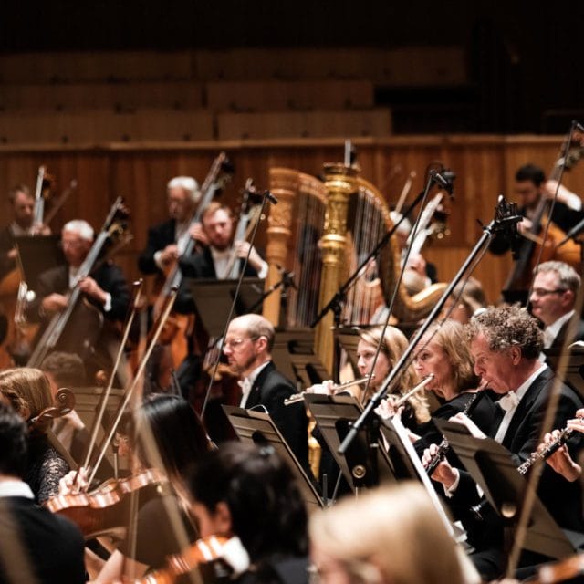 A cross section of the orchestra, with strings in the foreground and harps at the back