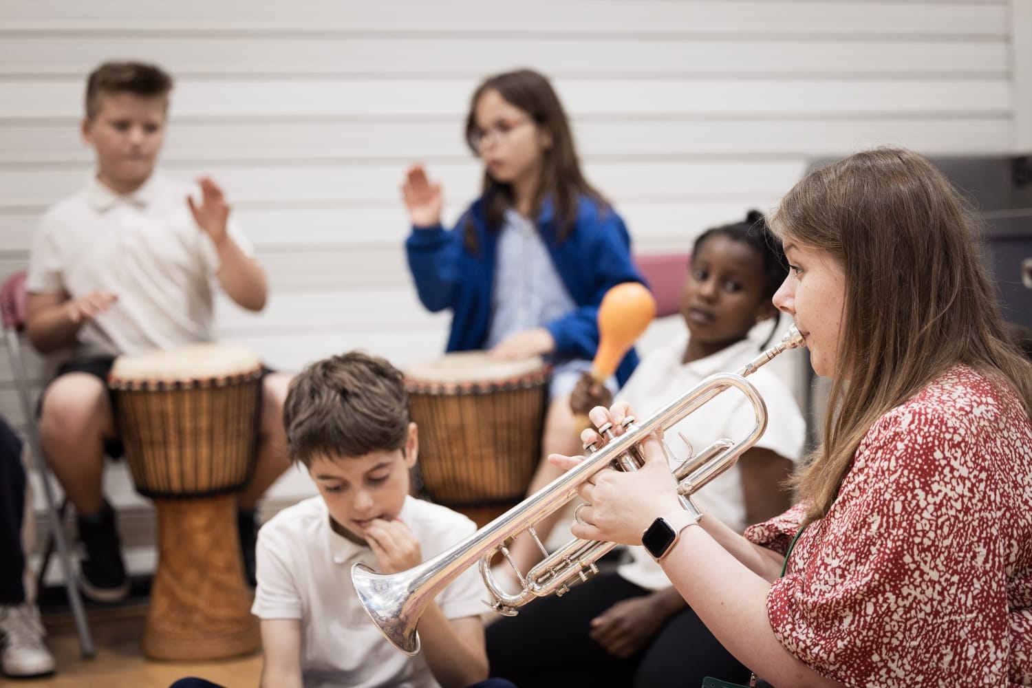 Children play percussion instruments and LPO player plays trumpet