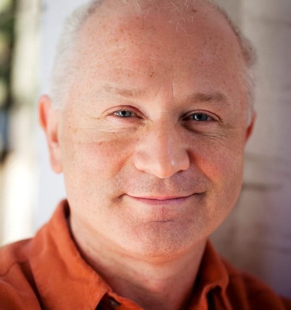 A smiling portrait of composer George Benjamin