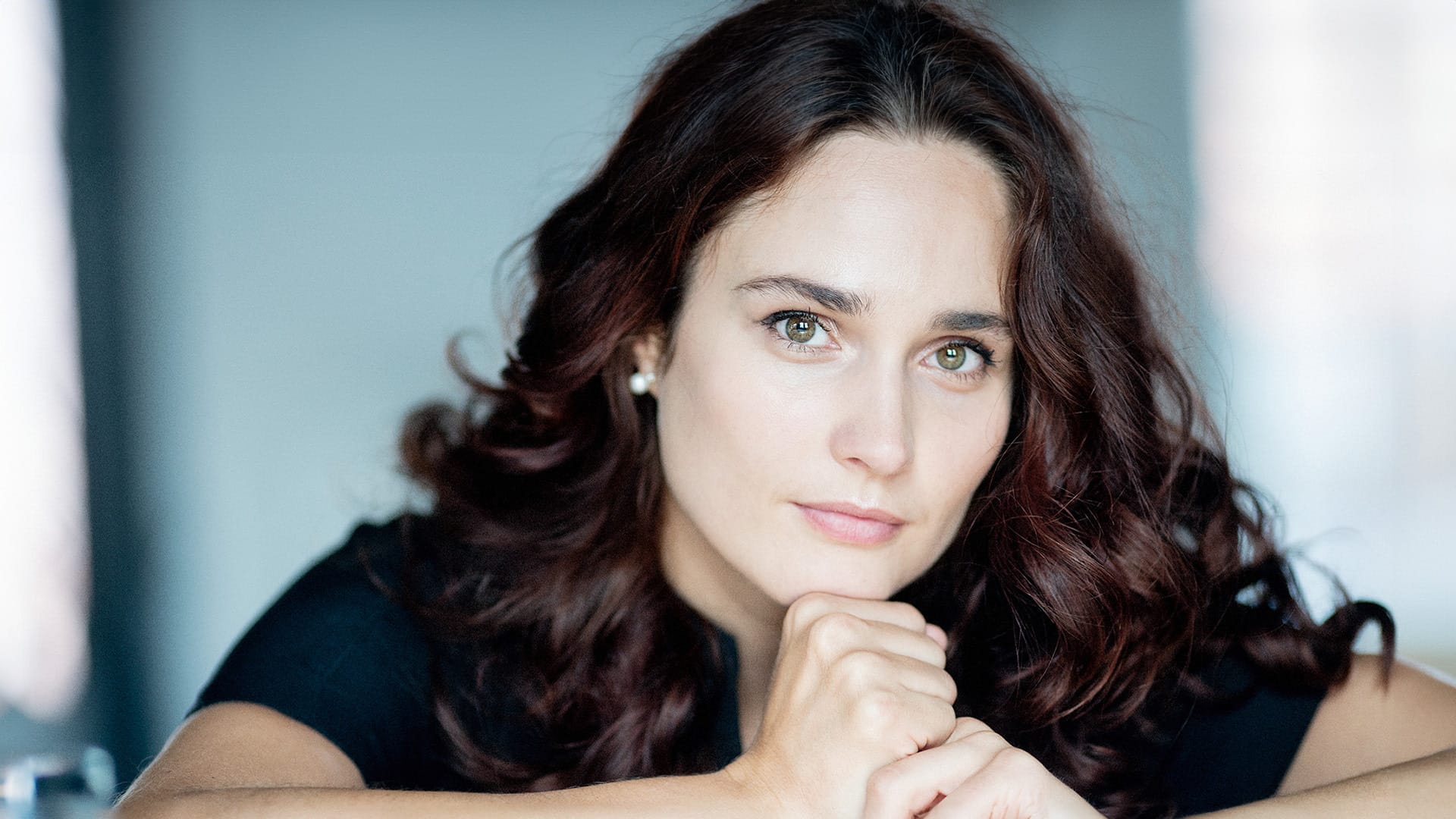 Pianist Anna Vinnitskaya close up with hands clasped underneath chin