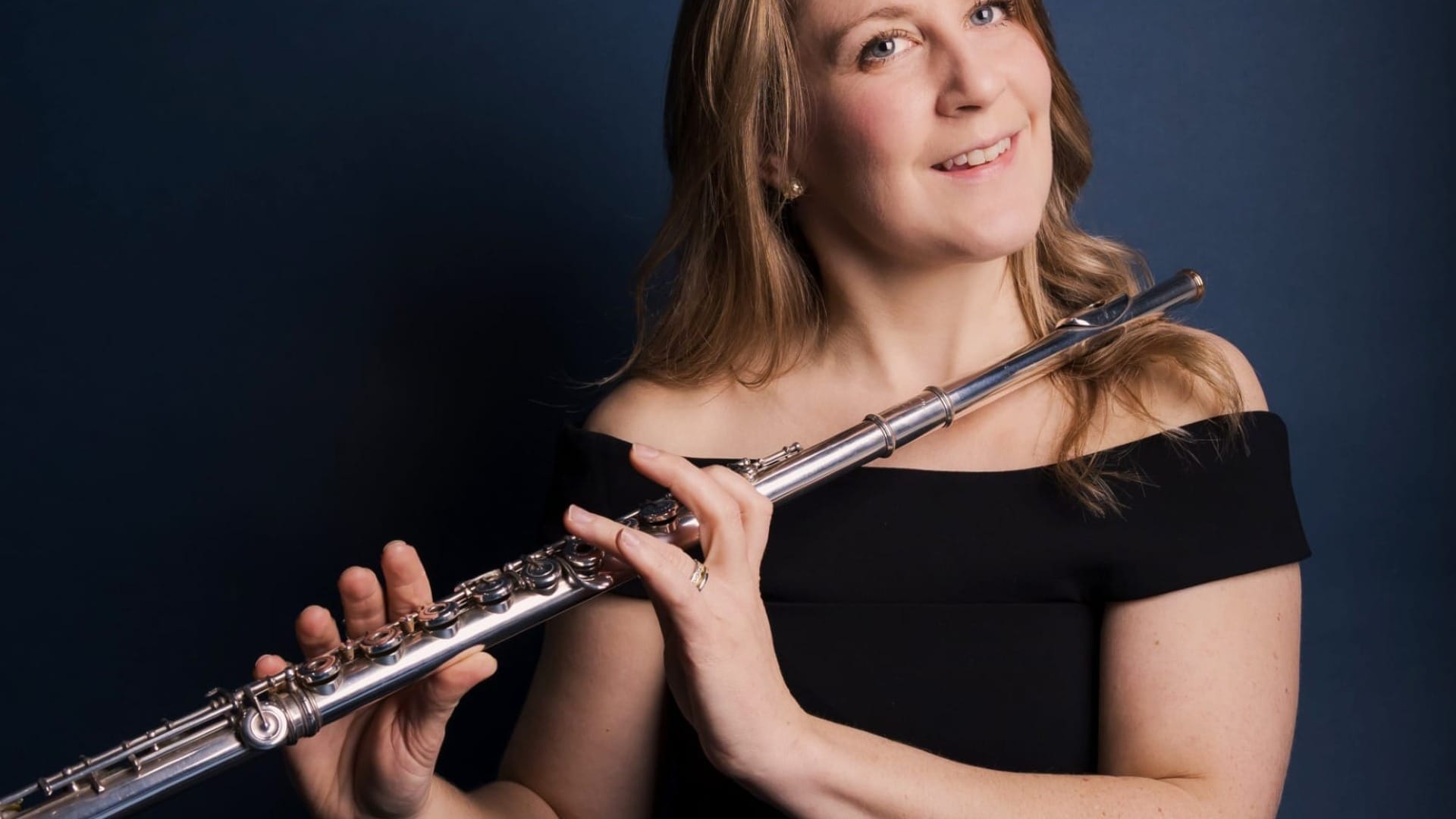 Hannah Grayson wearing a black dress and holding her flute
