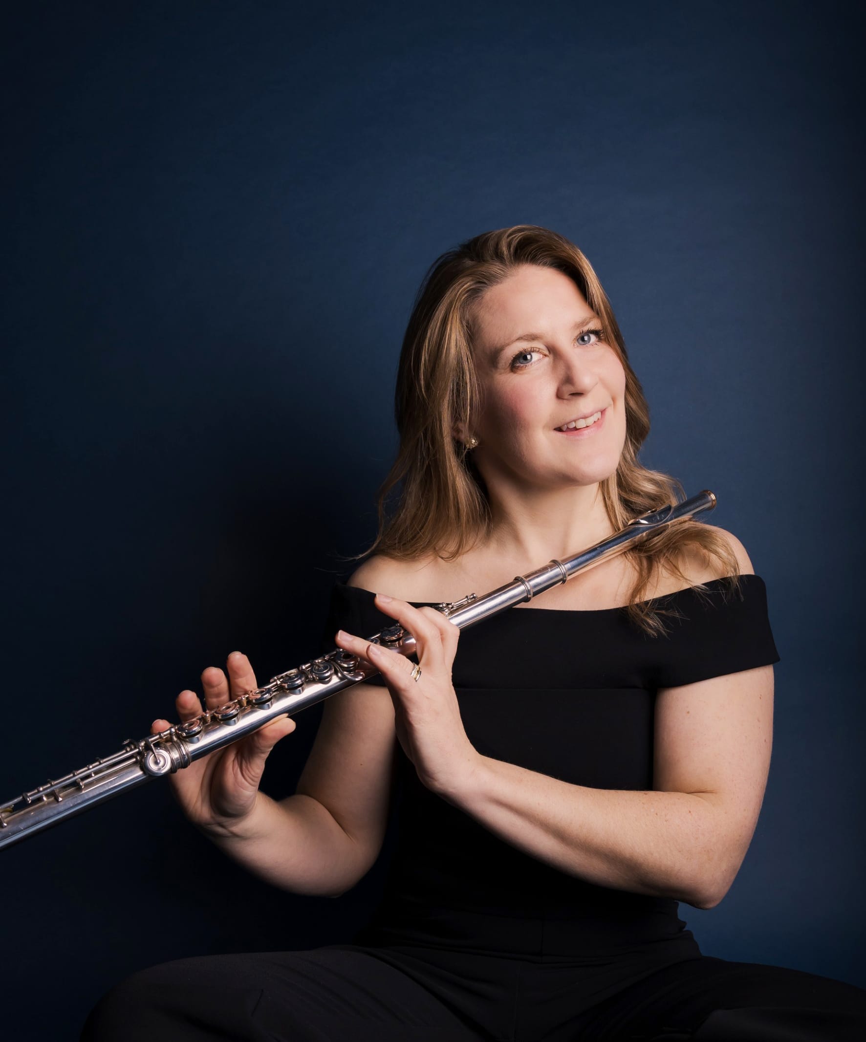 Hannah Grayson wearing a black dress and holding her flute