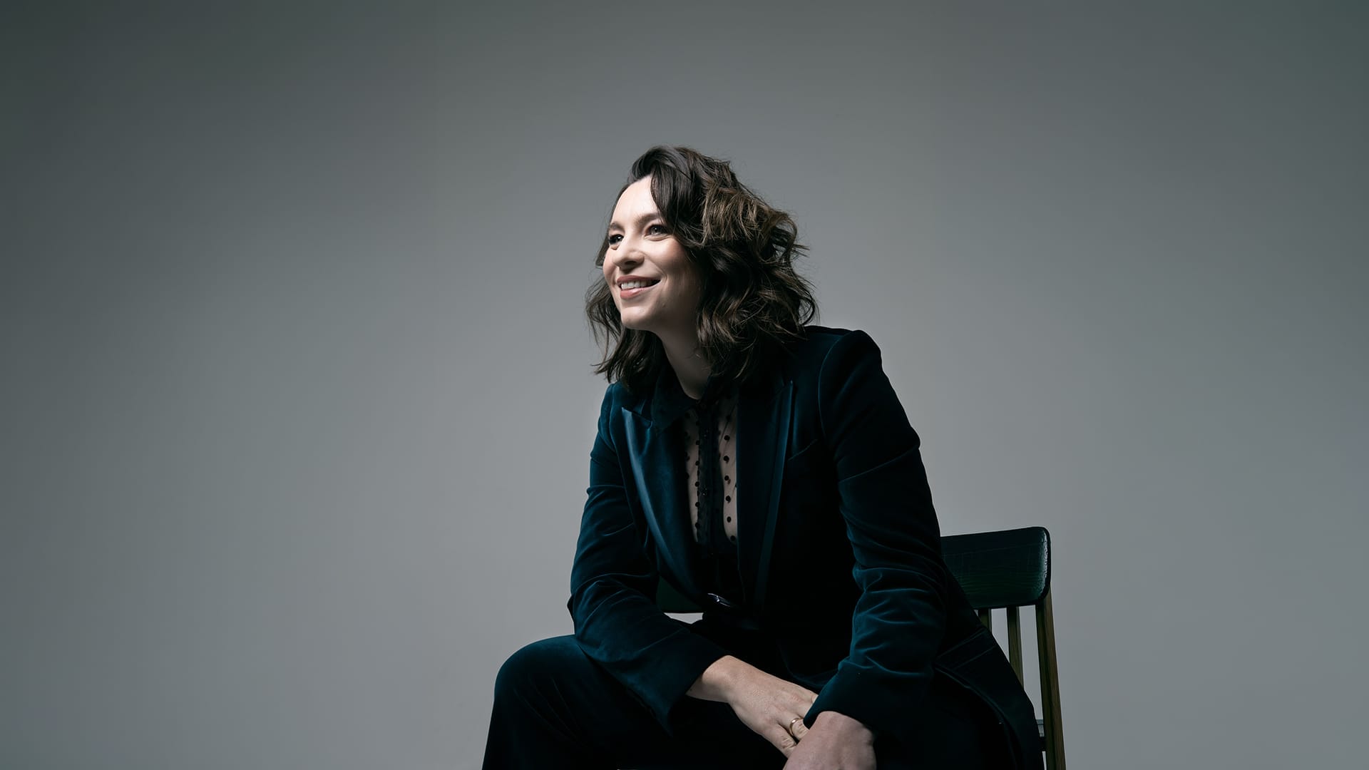 Soprano Natalya Romaniw, a woman with long dark hair, wearing an elegant black gown, formal portrait.