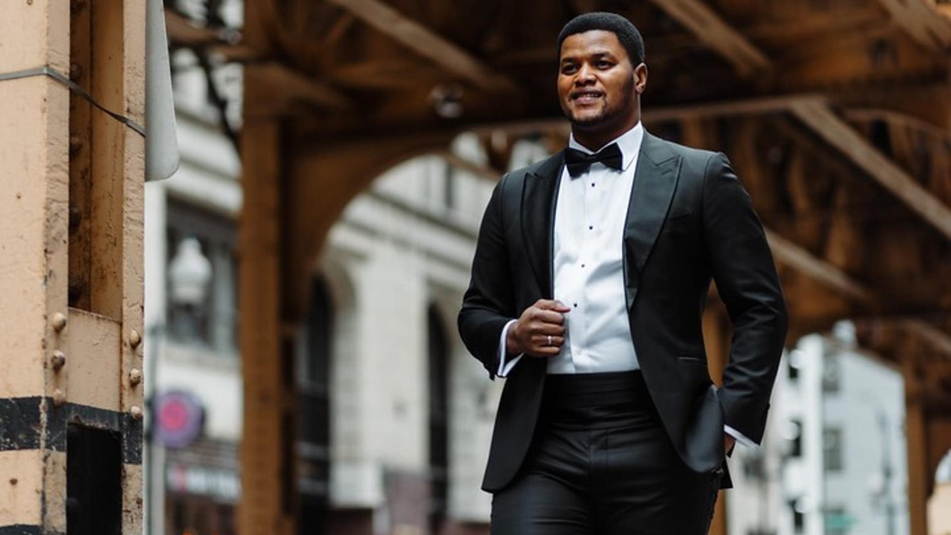Tenor Lunga Eric Hallam, a man wearing with brown archway beams in the background.