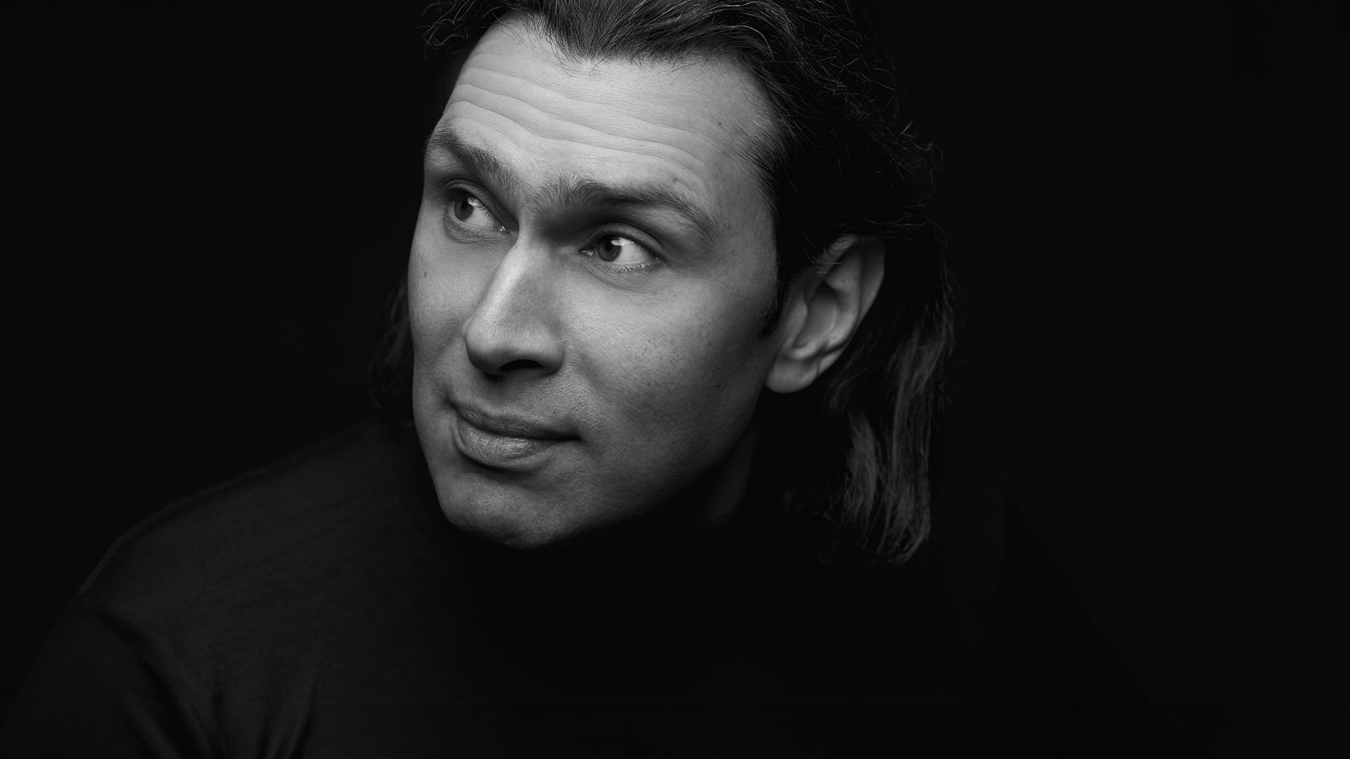 Conductor Vladimir Jurowski, a man with shoulder-length dark hair, black and white formal portrait.