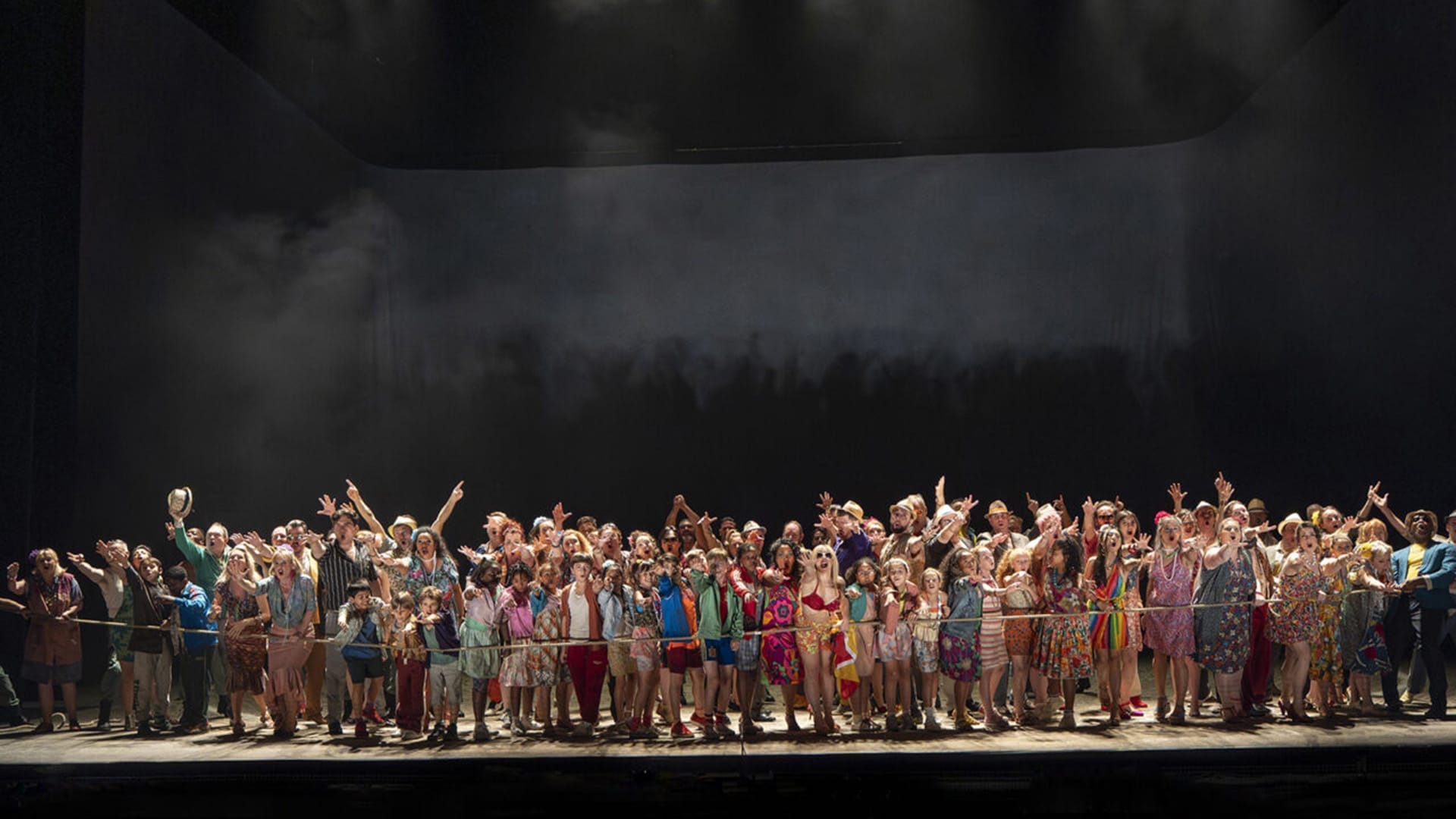 Members of the English National Opera Chorus on stage performing.
