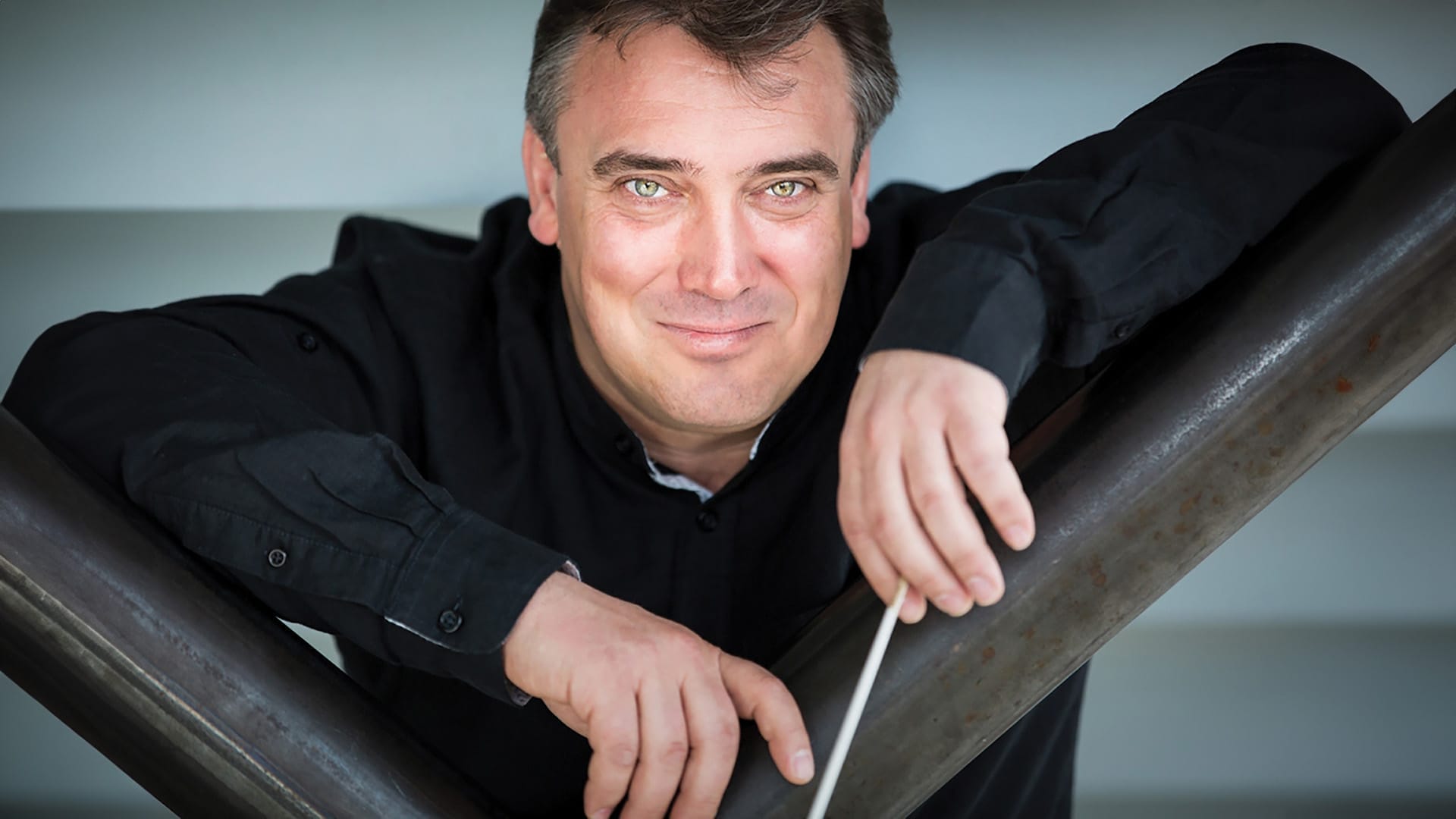 Conductor Jaime Martín, a man, smiling at the camera with a conductor's baton in his hands.